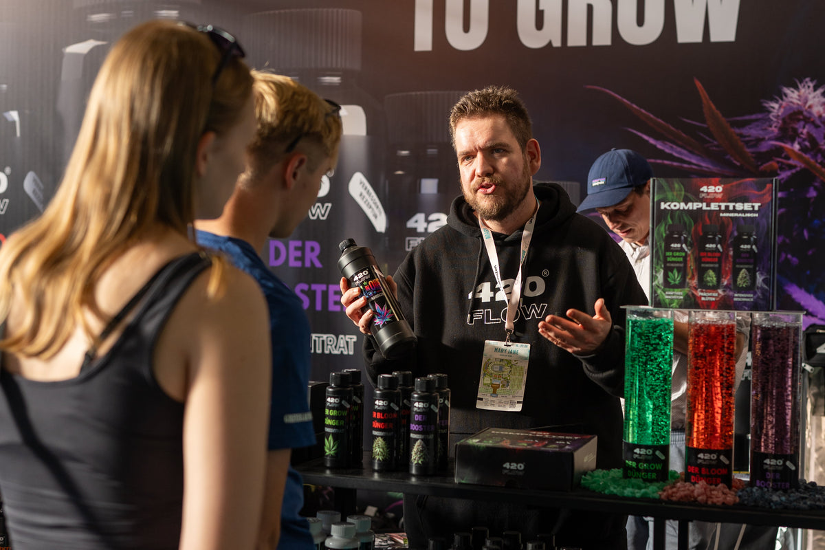 Ein Mitarbeiter von 420Flow erklärt am Messestand auf der Mary Jane Berlin Besuchern die Dünger-Produkte